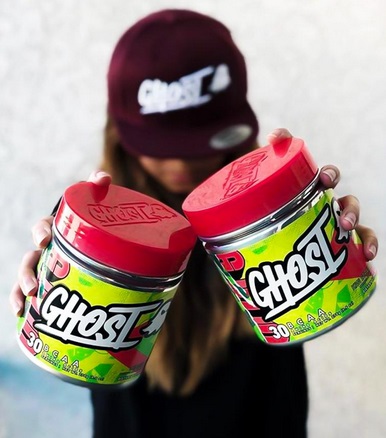 woman holding 2 tubs of ghost BCAAs